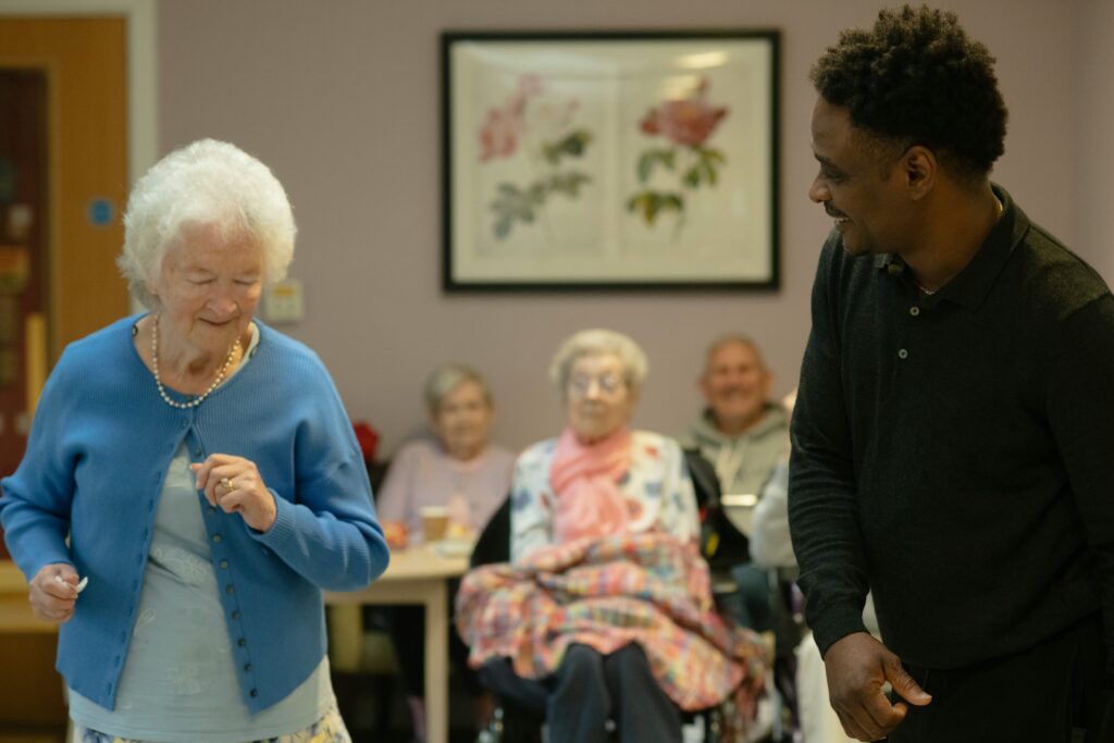A support worker running a group activity with older participants