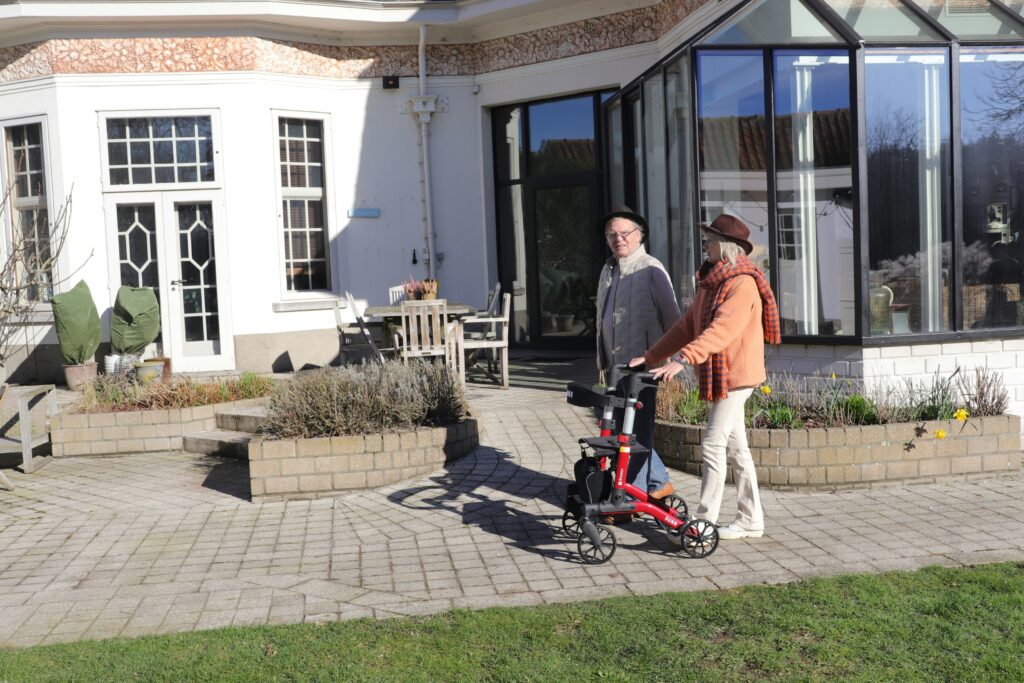 An older person using a walking frame outside their home in Box Hill