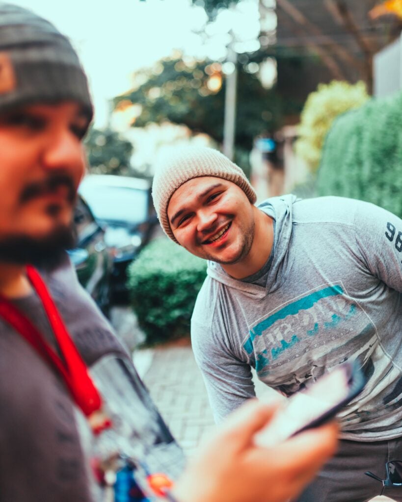 Two friends smiling together for a selfie outdoors