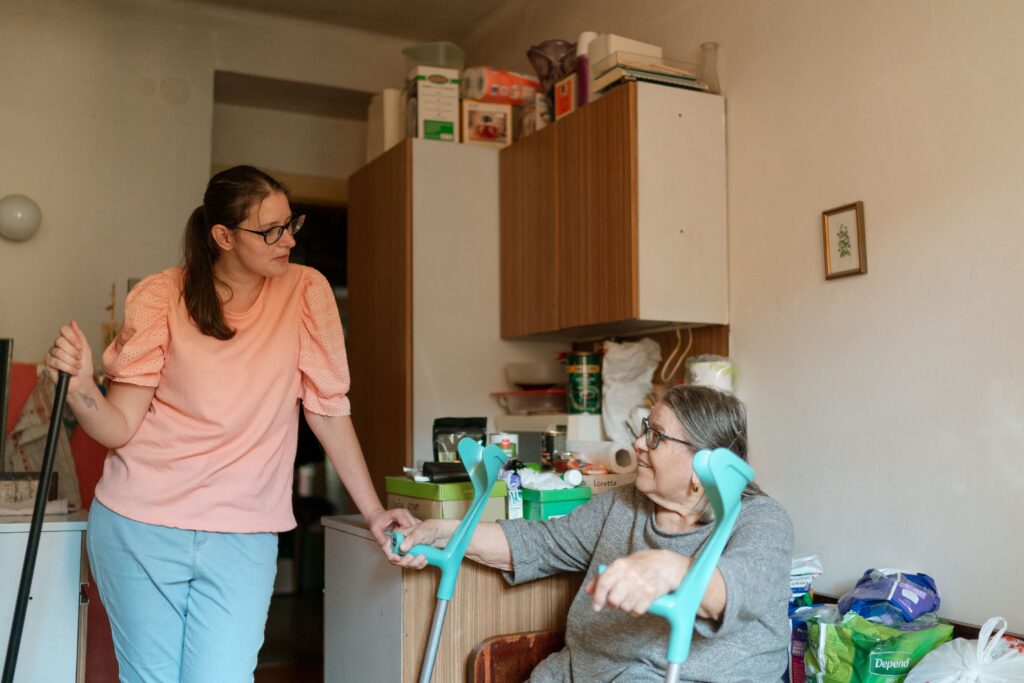 An iCare4U support worker assisting an older woman at home in her kitchen