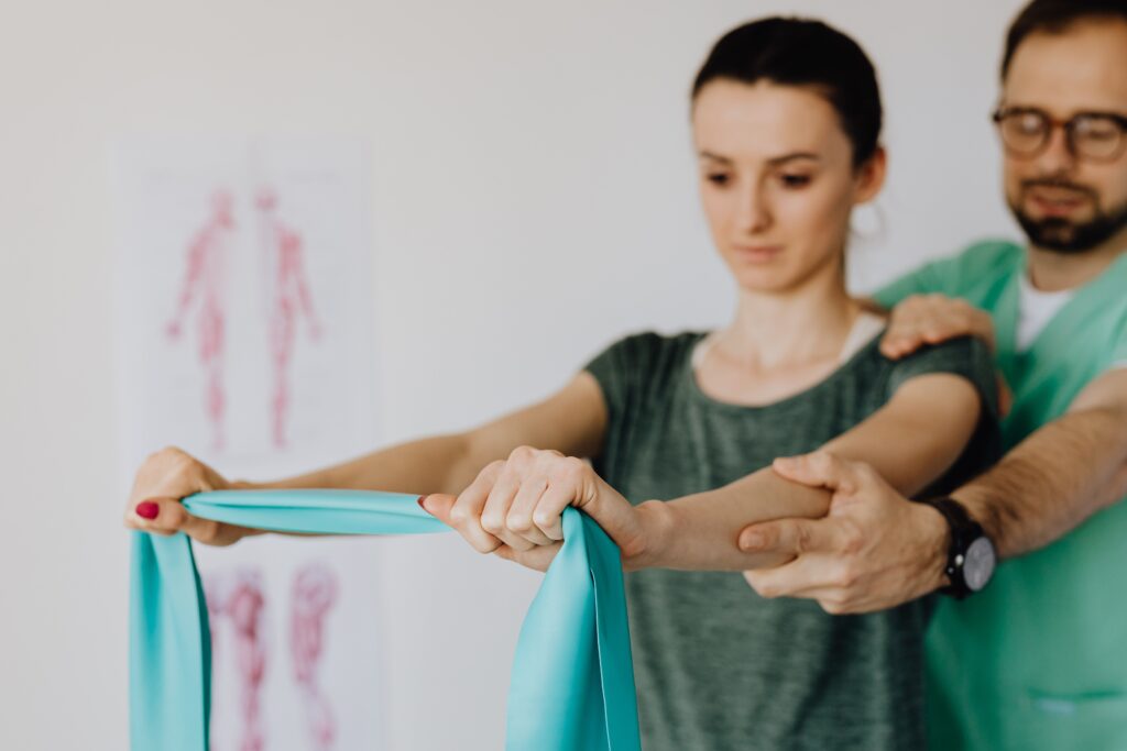 A physiotherapist guiding a young woman through a stretching exercise