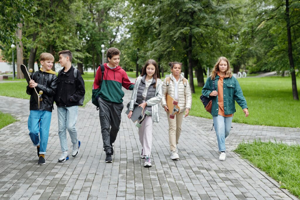 A group of friends walking together along a tree-lined path in a Melbourne park